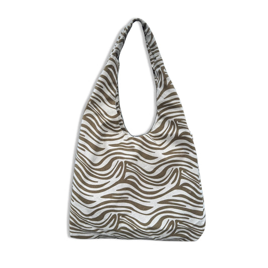 Borsa a sacca hobo da spiaggia in resistente tessuto canvas zebrato bianco e nero. Modello ultra leggero e capiente con manico largo da spalla. Dotata di una comoda tasca esterna posteriore con cerniera per gli oggetti personali. L'accessorio perfetto, comodo e super chic per completare i tuoi outfit estivi da spiaggia o piscina.