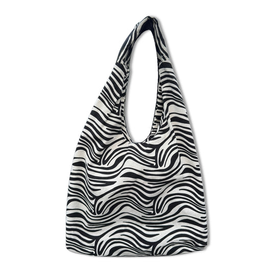 Borsa a sacca hobo da spiaggia in resistente tessuto canvas zebrato bianco e nero. Modello ultra leggero e capiente con manico largo da spalla. Dotata di una comoda tasca esterna posteriore con cerniera per gli oggetti personali. L'accessorio perfetto, comodo e super chic per completare i tuoi outfit estivi da spiaggia o piscina.